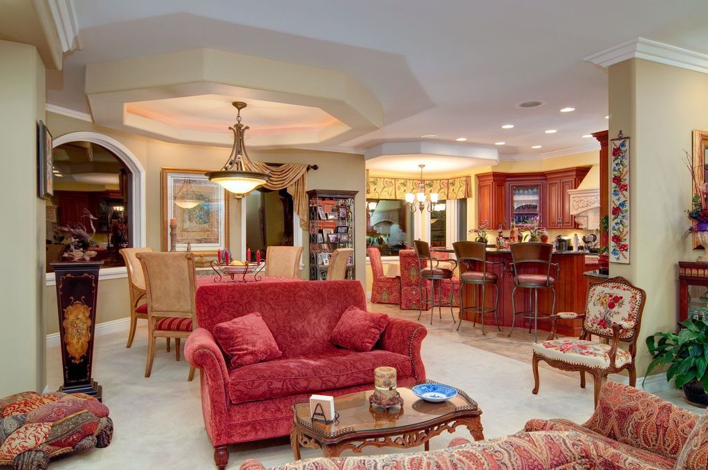 Mediterranean Great Room with Chandelier, can lights, sandstone tile floors, stone tile floors, Crown molding, picture window