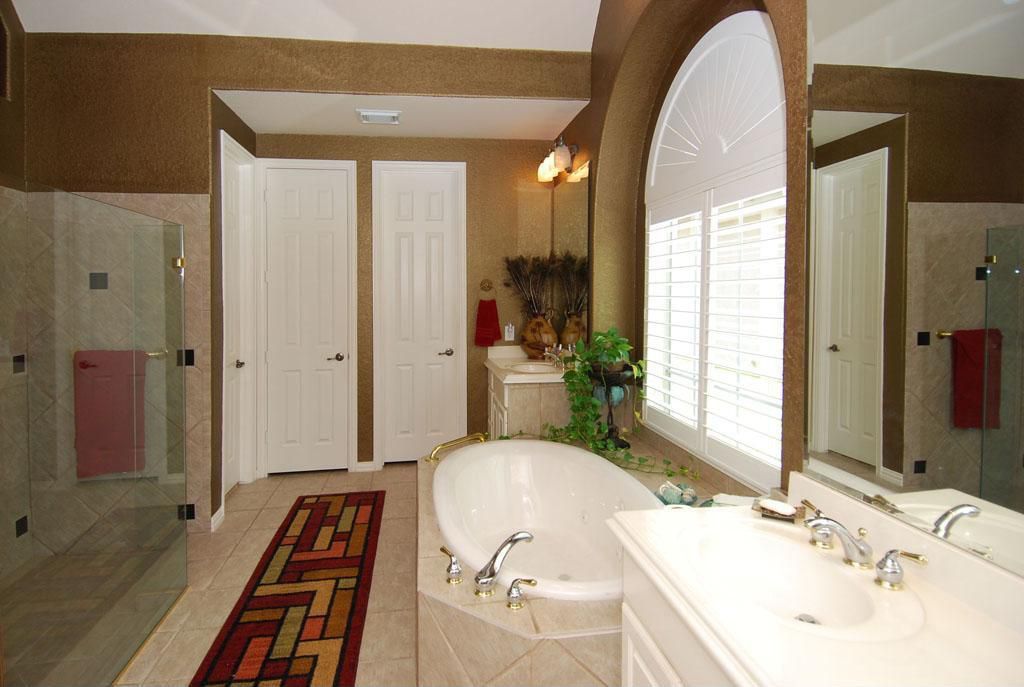 Traditional Master Bathroom with Corian counters, Wall Tiles, limestone tile floors, wall-mounted above mirror bathroom light