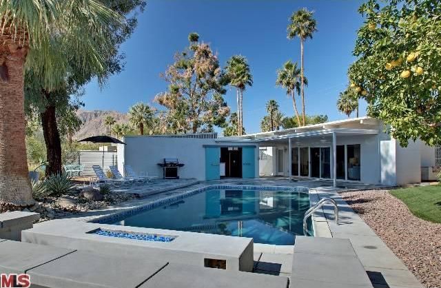 Contemporary Swimming Pool with Outdoor kitchen, Raised beds, Fire pit, Fence, sliding glass door, exterior tile floors