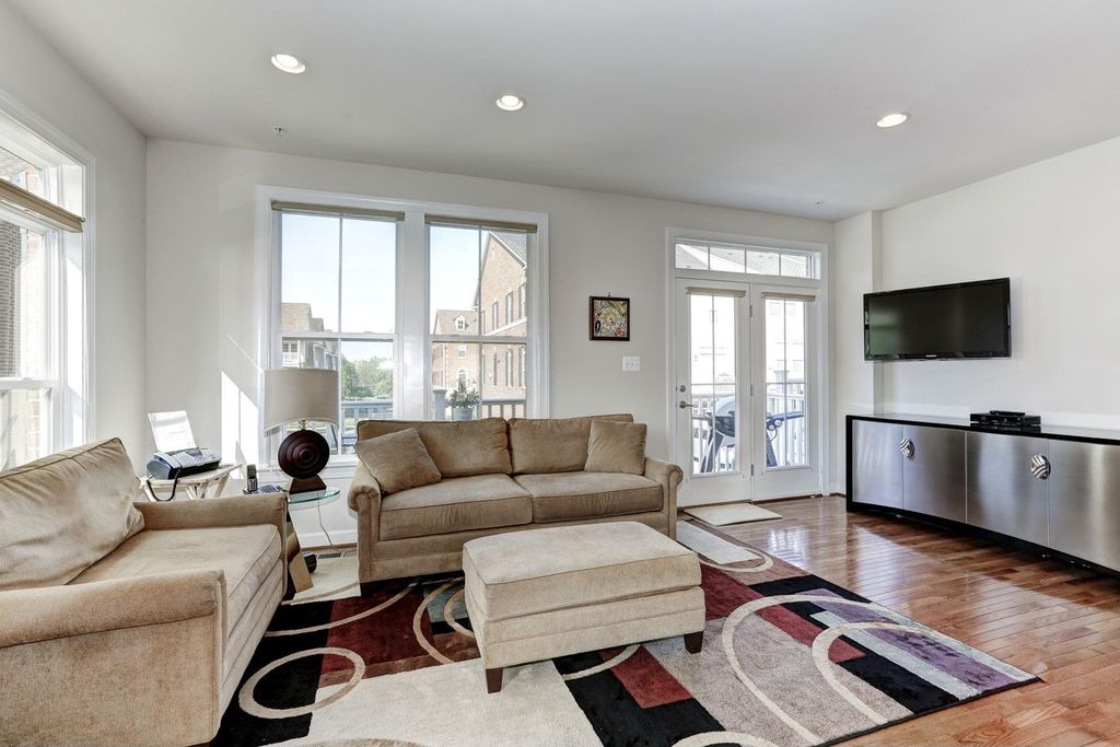 Contemporary Living Room with double-hung window, French doors, can lights, Transom window, Standard height, Hardwood floors