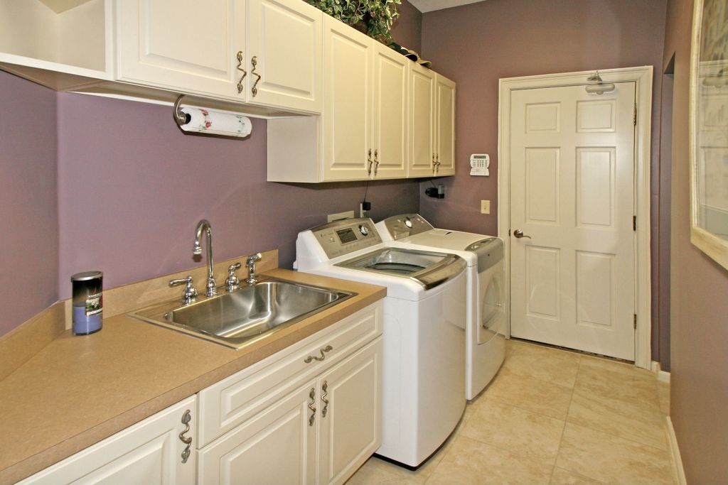Traditional Laundry Room with six panel door, Built-in bookshelf, Standard height, laundry sink, limestone tile floors, Paint